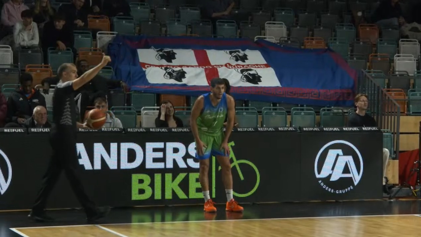 Ceron di fronte allo striscione del gruppo Centro Sardo Su Nuraghe di Amburgo