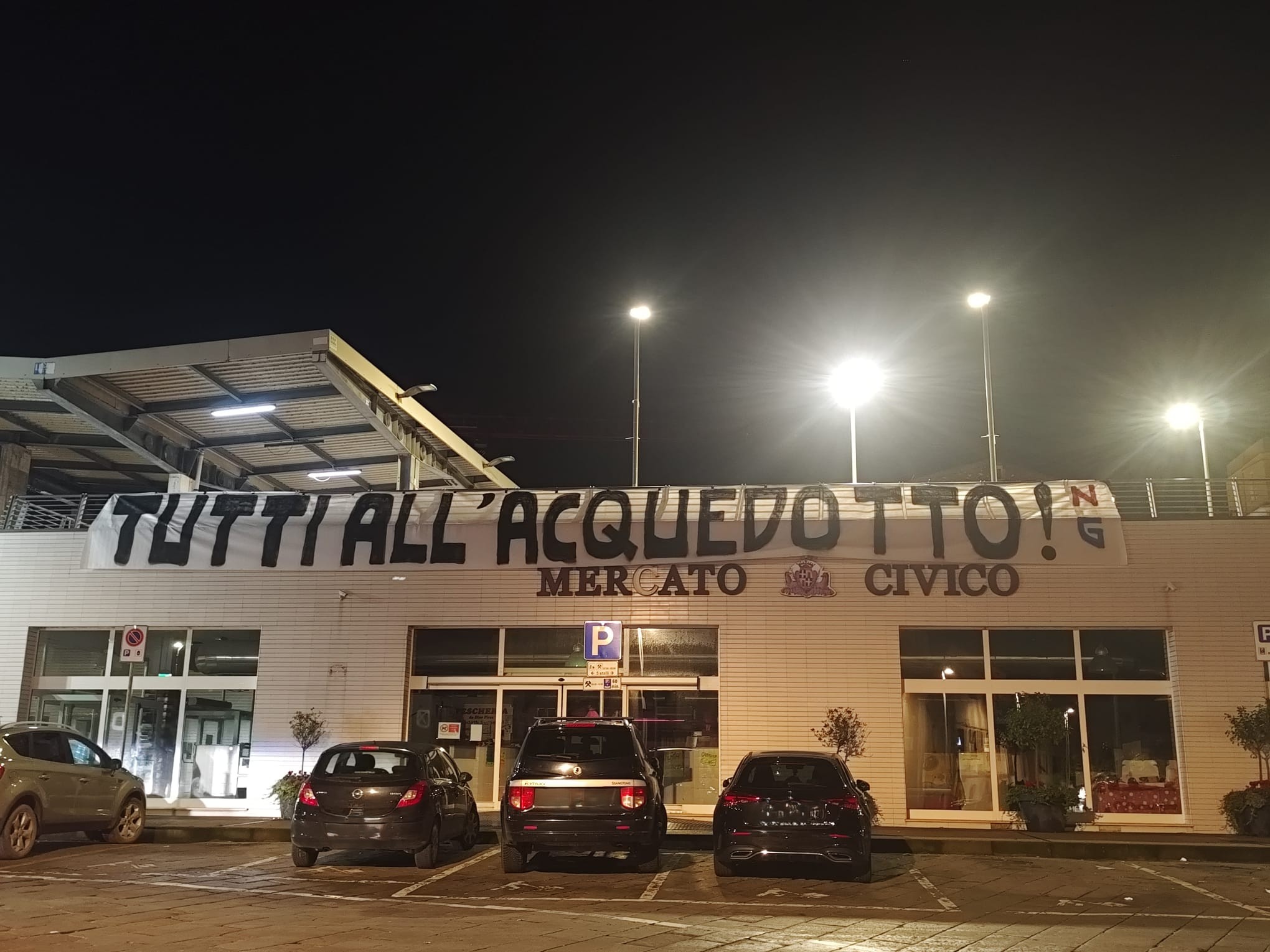 Uno degli striscioni, appeso al Mercato Civico: "Tutti all'Acquedotto"